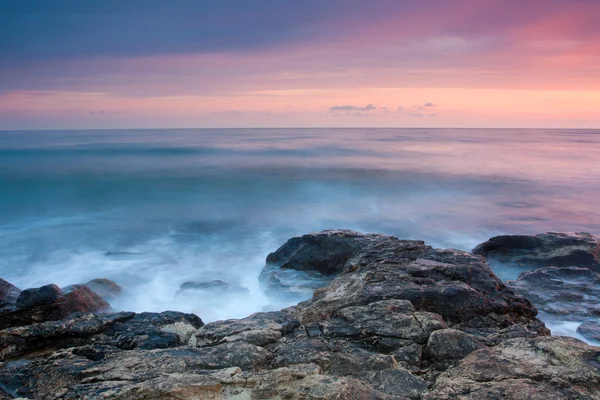 Gün batımında güzel kayalık deniz plaj — Stok fotoğraf
