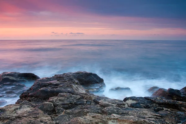 Bella spiaggia rocciosa al tramonto — Foto Stock