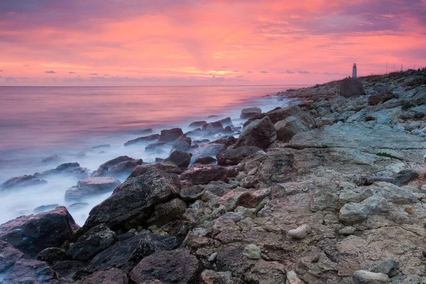 Smuk klippefyldt strand ved solnedgang - Stock-foto