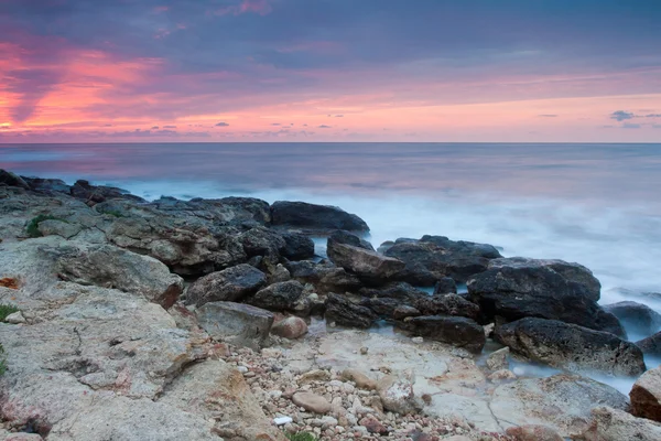 Schöner felsiger Meeresstrand bei Sonnenuntergang — Stockfoto