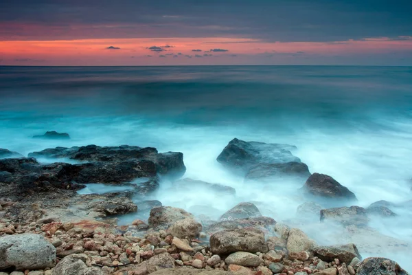 Bela praia de mar rochoso ao pôr do sol — Fotografia de Stock