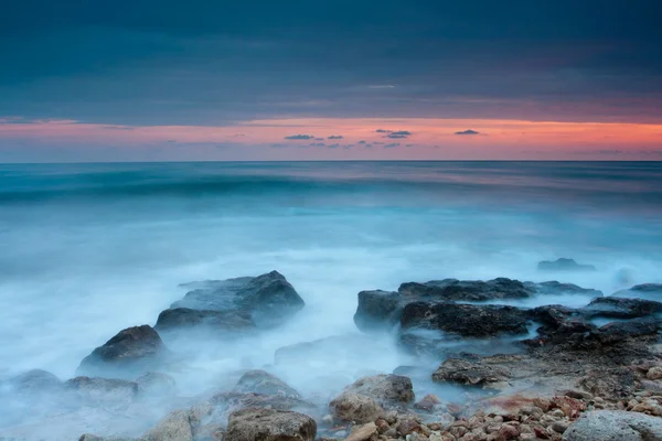 Prachtige rotsachtige strand bij de zonsondergang — Stockfoto
