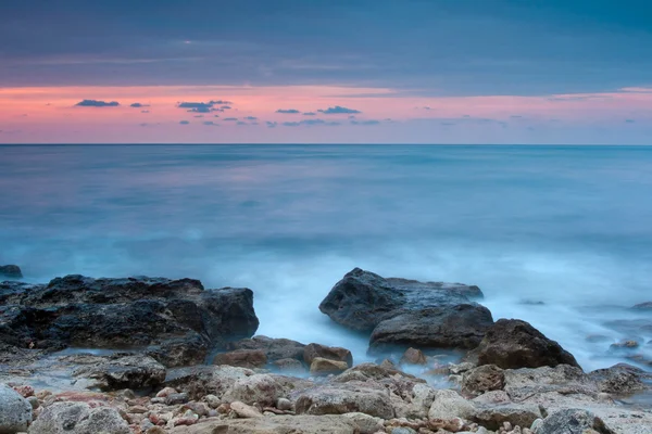 Beautiful rocky sea beach at the sunset — Stock Photo, Image