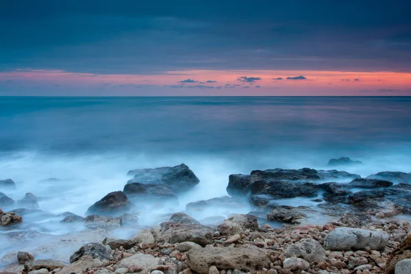Prachtige rotsachtige strand bij de zonsondergang — Stockfoto
