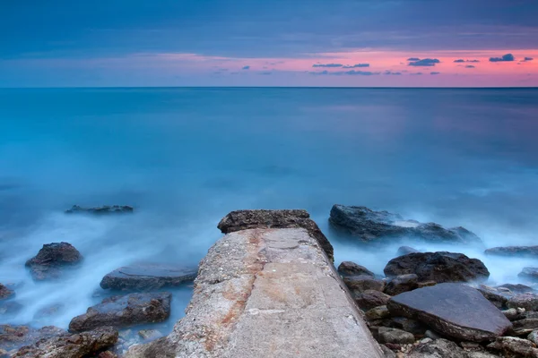 Belle plage de mer rocheuse au coucher du soleil — Photo