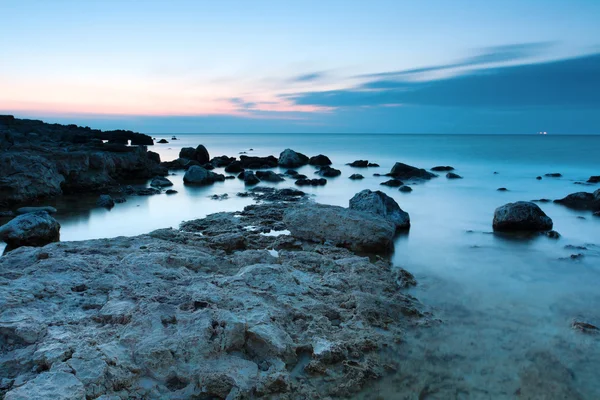 Belle plage de mer rocheuse au coucher du soleil — Photo