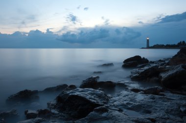 Nightly seascape with lighthouse and moody sky clipart