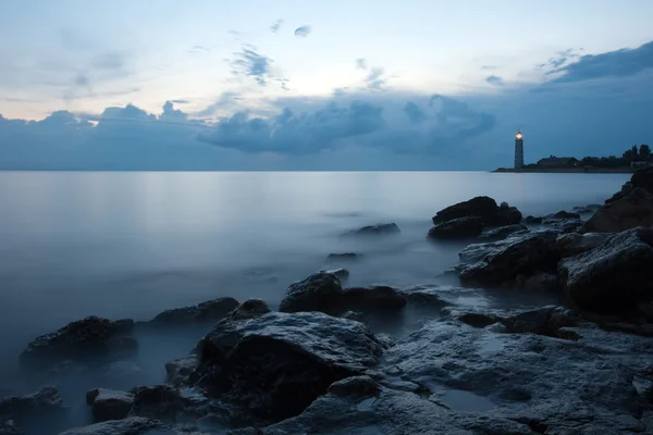 Notte paesaggio marino con faro e cielo lunatico — Foto Stock