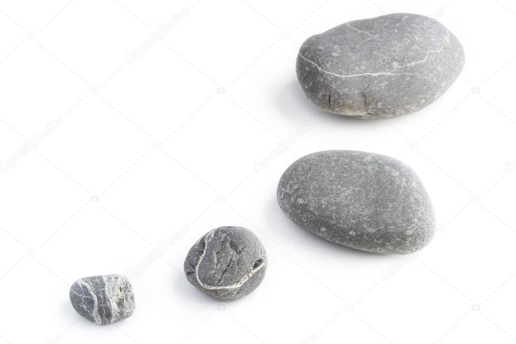 Four assorted size rocks on plain background