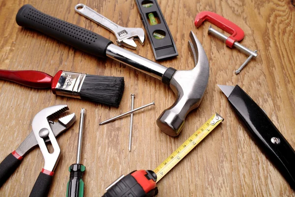 Assorted work tools on wooden panel — Stock Photo, Image