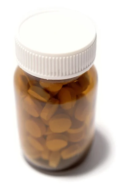 Comprimidos em garrafa no fundo liso — Fotografia de Stock