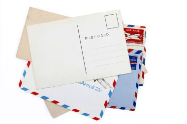 Postcard on pile of old air mail envelopes clipart