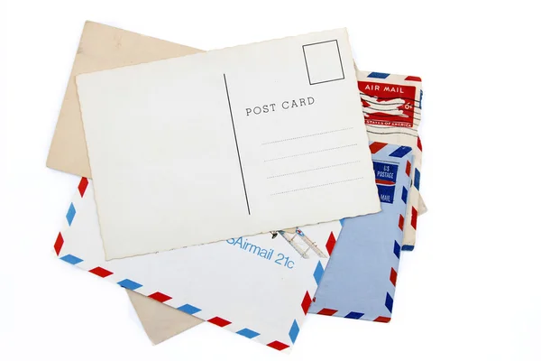 Briefkaart op stapel van oude lucht mail enveloppen — Stockfoto