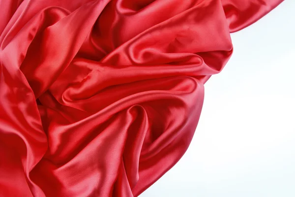 Tecido de seda vermelha no fundo liso — Fotografia de Stock