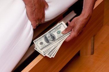 Dollar currency notes are hidden under the bed clipart