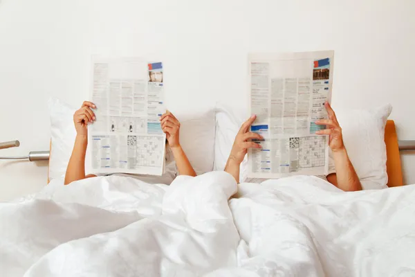 Διαβάζει εφημερίδα στο κρεβάτι — Φωτογραφία Αρχείου