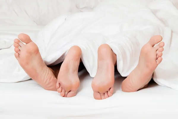 Ноги пари в ліжку . — стокове фото