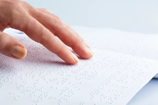 Braillovo písmo a prst. knihy v Braillově písmu — Stock fotografie