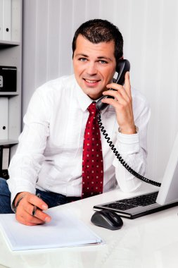 Businessman in office with telephone clipart