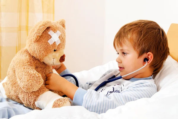 Niño enfermo examinado teddy con estetoscopio — Foto de Stock