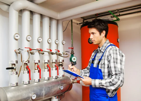 Heating engineer in the boiler room Stock Image