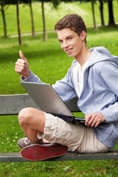 Tiener met laptop outdoors — Stockfoto