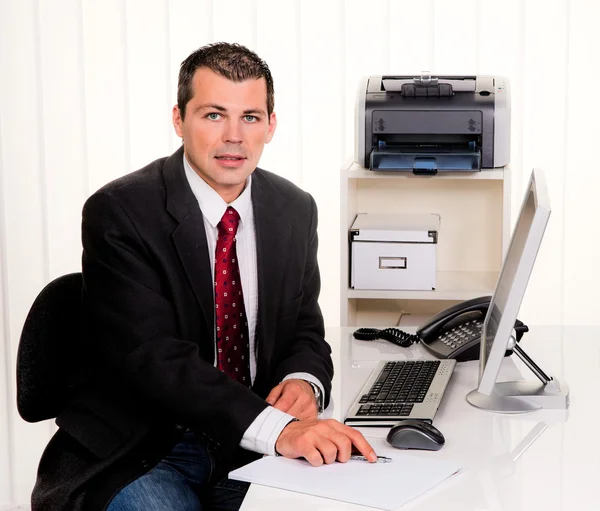 Empresário no cargo com um computador — Fotografia de Stock