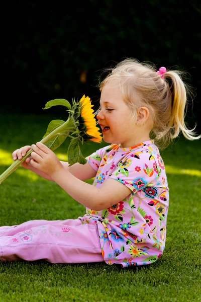 Niño con un girasol en el jardín en verano — Foto de Stock