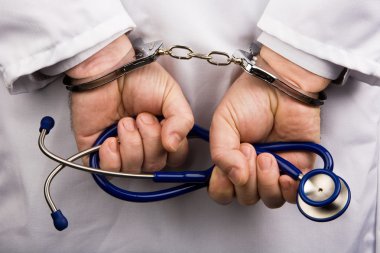 Doctor with stethoscope and handcuffs clipart