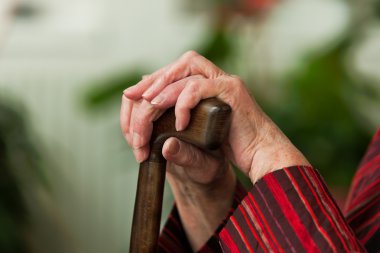 Handicapped elderly woman with a walking cane clipart