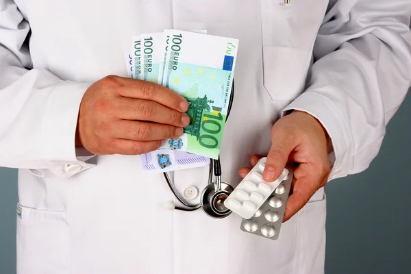 A doctor with dollar bills and pills — Stock Photo, Image
