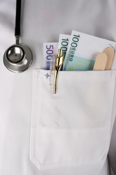 Um médico com notas de dólar — Fotografia de Stock