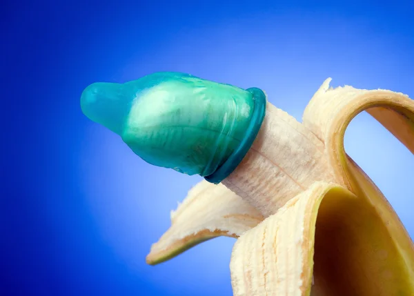 Preservativo con banana. icona per la prevenzione e gli aiuti . — Foto Stock