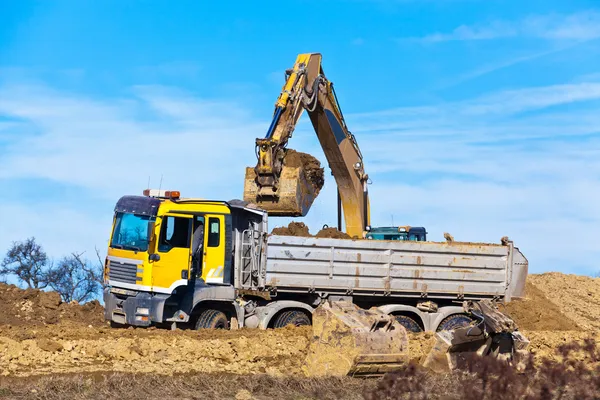 Grävmaskiner i arbetet på byggarbetsplatsen — Stockfoto