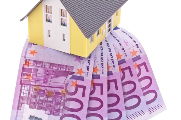 Muchos billetes de banco en euros y una casa —  Fotos de Stock