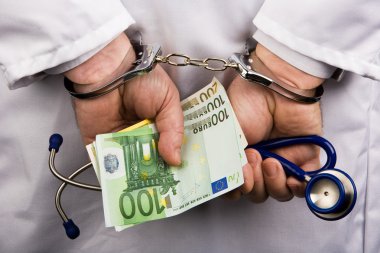 A doctor with euro bank notes and handcuffs clipart