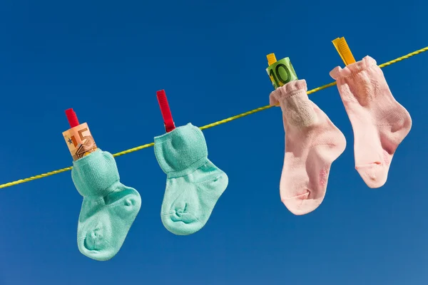 Chaussettes bébé sur corde à linge avec euro — Photo