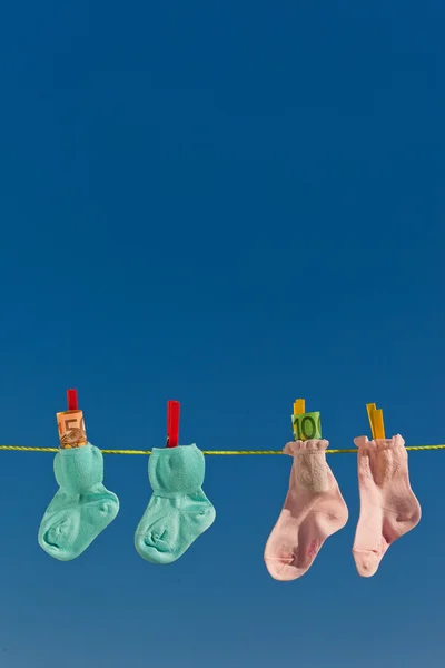 Baby strumpor på klädstreck med euro — Stockfoto