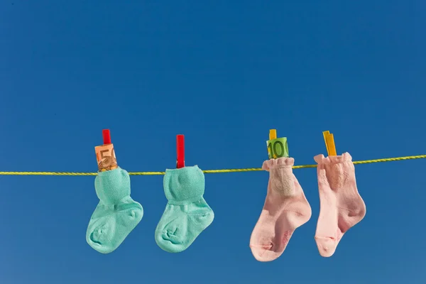 Calcetines de bebé en tendedero con euro — Foto de Stock