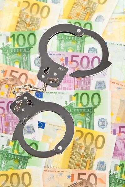 Банкноты и наручники евро — стоковое фото