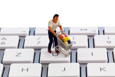 Figure with cart on computer keyboard clipart