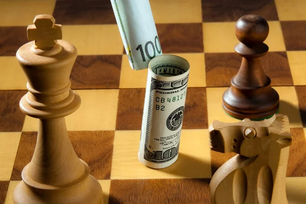 Шахматы с долларом и евро — стоковое фото