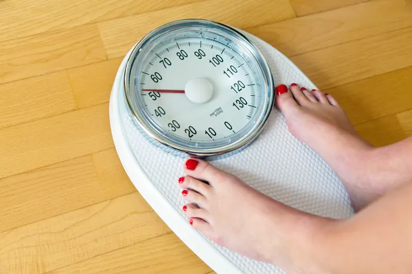 Feet of a woman on bathroom scales — Stock Photo, Image