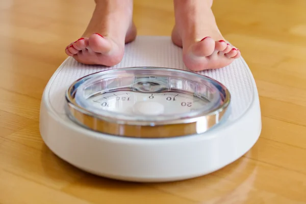 Feet of a woman on bathroom scales — Stock Photo, Image