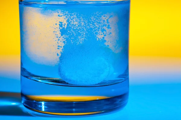Tablet dissolves in water on glass — Stock Photo, Image