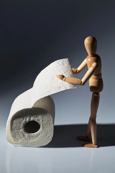 Figurine en bois sur un rouleau de papier toilette — Photo
