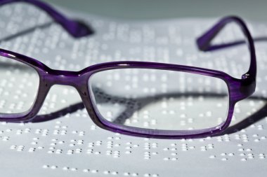 Glasses and book in braille. braille clipart