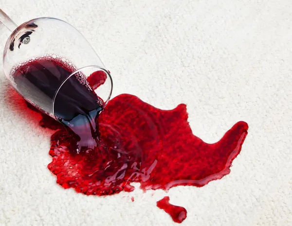 Красное вино пролилось на ковер — стоковое фото