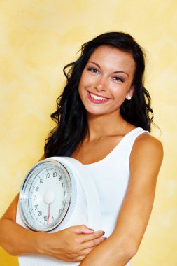 Woman with scales after a successful diet clipart
