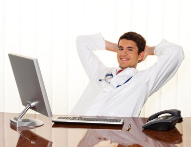 Successful doctor sits at desk clipart